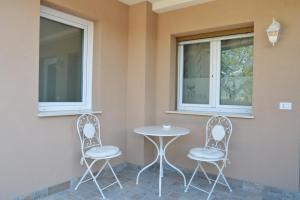 two chairs and a table and two windows at Affitta camere La Fenice di Folli Lorella in Puegnago +47 photos