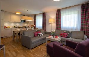 ein Wohnzimmer mit 2 Sofas und einer Küche in der Unterkunft Pradas Resort Brigels in Brigels