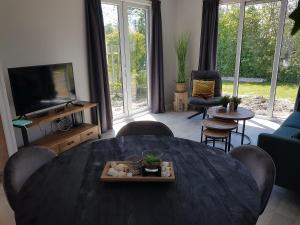 a living room with a table and a tv at Chateau Quak in Petten
