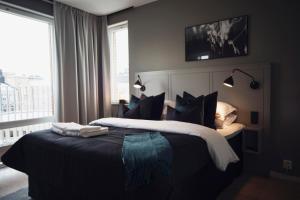 a bedroom with a bed with black and white at Sky Hotel Apartments, Hospitalstorget in Linköping