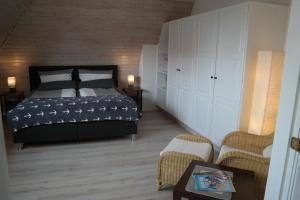 a bedroom with a bed and a couch and chairs at Ferienhaus Knippschild in Norderney