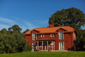 una casa roja con un árbol delante en Steningevik, en Märsta