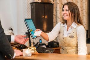 a woman is handing a piece of paper to a customer at Steningevik in Märsta