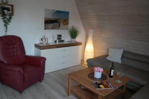 ein Wohnzimmer mit einer Couch, einem Sessel und einem Tisch in der Unterkunft Ferienhaus Knippschild in Norderney