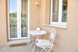 a table and two chairs on a porch with windows at Affitta camere La Fenice di Folli Lorella in Puegnago