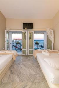 a bedroom with two beds and a view of the ocean at Fratelli Rooms in Tinos Town