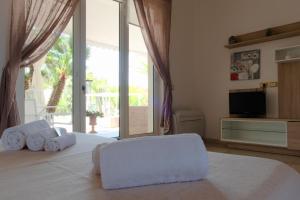a bedroom with a large white bed with a television at Li Carlucci in Cannole