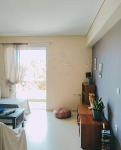 ein Wohnzimmer mit einem Bett und einem großen Fenster in der Unterkunft Xrysa's Garden in Mesolongi