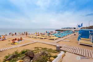 a beach with lounge chairs and people on the sand at Apartment Riviera in Fontanka