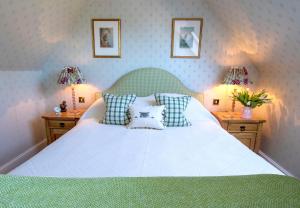 una camera da letto con un grande letto bianco con due lampade di Balnagown Estates a Kildary