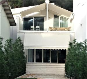 a white house with a white awning on it at Villa Leyland in Golem