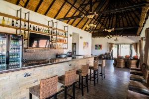 a bar in a restaurant with a bunch of chairs at Hunters Paradise Cottages in Bungoma