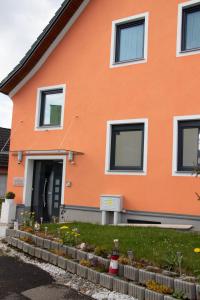 uma casa laranja com uma porta e algumas flores em Die Schlafstube - Bed & Breakfast em Zeltweg