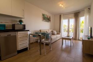 eine Küche und ein Wohnzimmer mit einem Tisch und einem Sofa in der Unterkunft Vistamarina A 401 by IVI Real Estate in Torremolinos