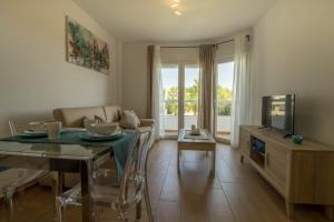 ein Wohnzimmer mit einem Esstisch und einem TV in der Unterkunft Vistamarina A 401 by IVI Real Estate in Torremolinos