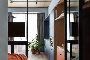 Habitación con 1 dormitorio con paredes azules y TV. en Beckett Locke en Dublín