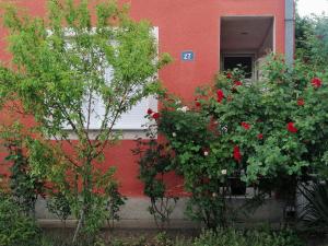 un bâtiment rouge avec des fleurs devant une fenêtre dans l'établissement Apartman Nana Jagodina, à Jagodina