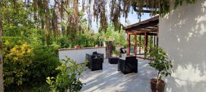 a patio with black chairs under a tree at Il Ruscello in San Severino