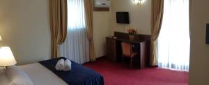 Habitación de hotel con cama y escritorio en Hotel Antiche Terme Benevento en Benevento