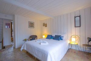 um quarto com uma grande cama branca com almofadas azuis em 34 Notre Dame - PRETTY TRIPLEX HOUSE IN HONFLEUR-NEAR THE OLD PORT em Honfleur