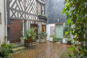 un patio de una casa antigua con macetas en 34 Notre Dame - PRETTY TRIPLEX HOUSE IN HONFLEUR-NEAR THE OLD PORT, en Honfleur