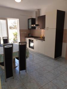 a kitchen with a table and a white refrigerator at Seaside Stay Rošić 2 in Ivan Dolac