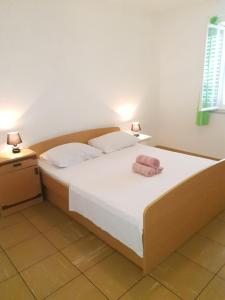 a bedroom with a bed with a towel on it at Seaside Stay Rošić 2 in Ivan Dolac