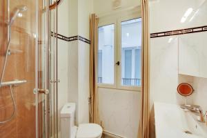 Suite junior avec balcon et vue sur Arc de Triomphe في باريس: حمام مع دش ومرحاض ومغسلة
