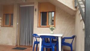 a small table with two blue chairs and a vase of flowers at ESCAPADA RELAX in Arroyo Frio