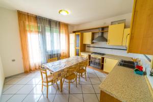 a kitchen with a table and chairs and a kitchen with yellow cabinets at Uliana Top House in Chioggia