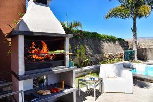 einen Außenofen mit einem Kamin neben einem Pool in der Unterkunft Sol 21 by VillaGranCanaria in Arguineguín