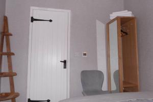a bedroom with a door and a chair and a mirror at The Welsh Toll House in Carmarthen