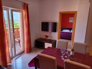 Un comedor con una mesa y un dormitorio. en Apartment Valerija, en Baška