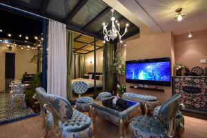 a living room with a large screen tv and chairs at 晓院 Hue Garden in Huidong
