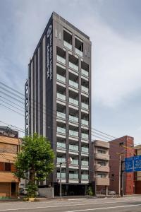 wysoki budynek z znakiem na boku w obiekcie HOTEL SUITE HIROSHIMA HAKUSHIMA w mieście Hiroszima