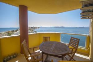 un tavolo e sedie su un balcone con vista sull'oceano di Spanish Connection - Playa Principe a La Manga del Mar Menor