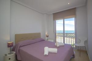 1 dormitorio con cama morada y balcón en Spanish Connection - Playa Principe, en La Manga del Mar Menor