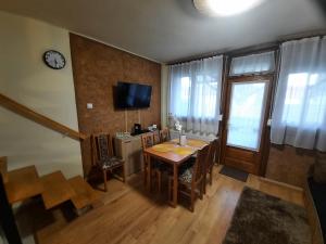 une salle à manger avec une table, des chaises et une horloge dans l'établissement For You Apartman Gyula, à Gyula