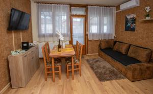 - un salon avec une table et un canapé dans l'établissement For You Apartman Gyula, à Gyula