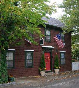 una casa de ladrillo rojo con una bandera americana en ella en Melville House Newport, en Newport