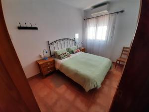 a small bedroom with a bed and a window at Apartamentos el Motor Tejeda in Tejeda