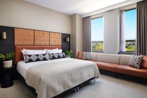 a bedroom with a bed and a couch and windows at Malmaison York in York