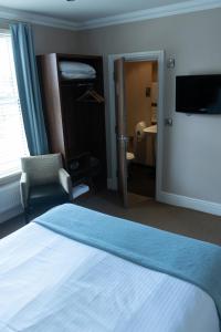 Habitación de hotel con 1 cama, TV y 1 dormitorio. en The Buxted Inn, en Buxted