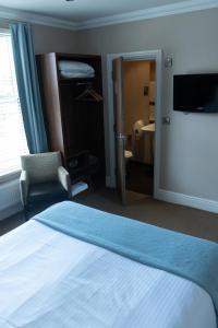 a hotel room with a bed and a tv and a bedroom at The Buxted Inn in Buxted