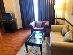 a living room with two chairs and a coffee table at Hotel President in Jalandhar