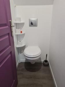 - białą toaletę w łazience z fioletowymi drzwiami w obiekcie Gite de Murat w mieście Murat