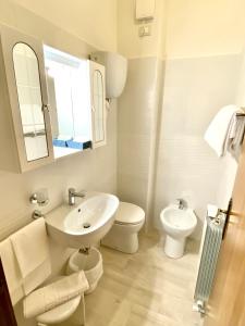uma casa de banho branca com um lavatório e um WC em Residence Signa em Perugia