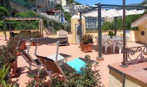 a patio with tables and chairs on a roof at Stella Maris Holidays in Maiori