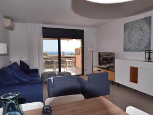 a living room with a blue couch and a table at Villa els ametllers in Sant Feliu de Guíxols