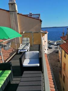 a balcony with two lounge chairs and the water at Apartments Gina in Piran